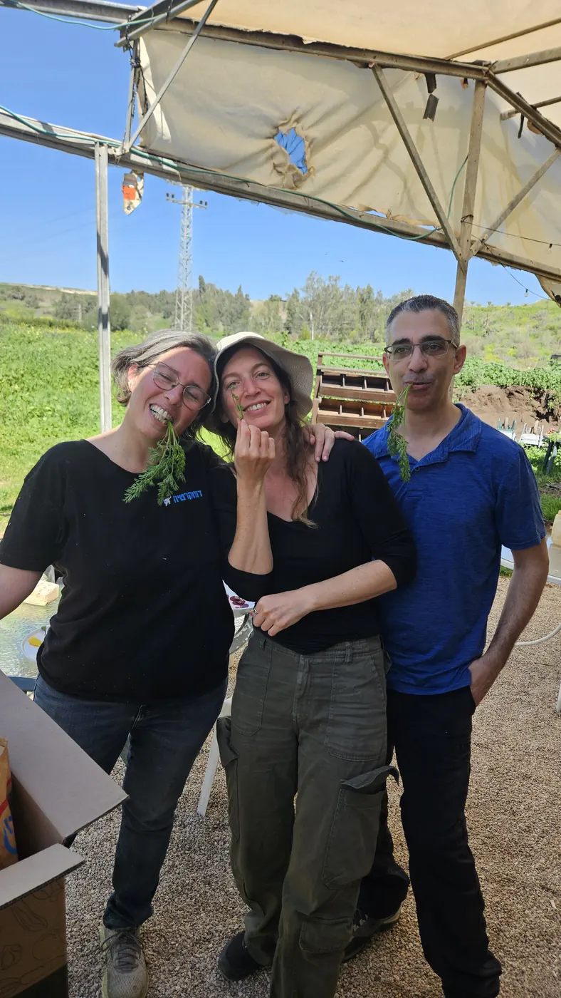 צוות החווה נהנה מעלי גזר טריים מהשדה