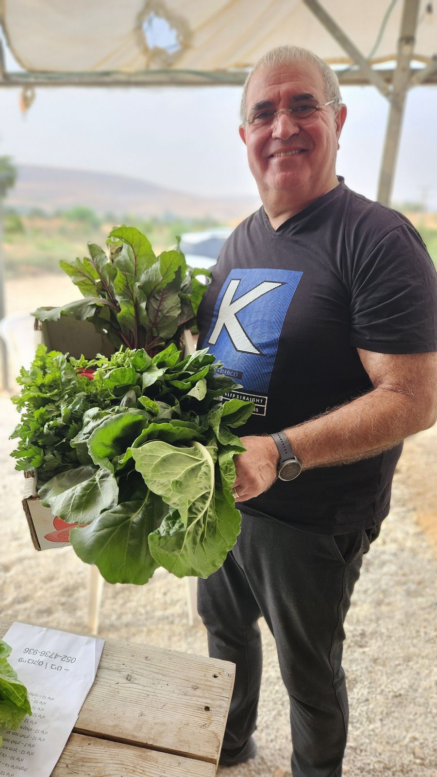 לקוח עם קופסת ירקות טריים מהחווה